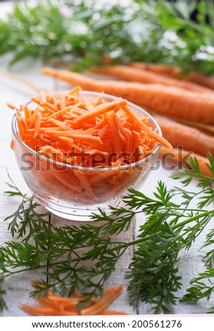 Grated carrots in bowl  on white table. Selective focus.