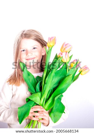 Beautiful girl holding a bouquet of colorful tulip flowers on a light background. 8 march or Womans day . Mother's day. Festive greeting concept.