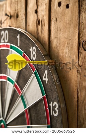 Darts game. Throwing darts at the target. One yellow dart missed the target
