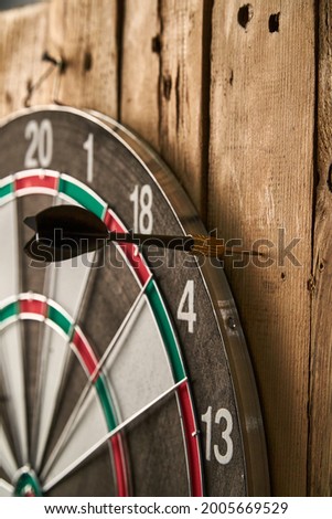 Darts game. Throwing darts at the target. One black dart missed the target Royalty-Free Stock Photo #2005669529