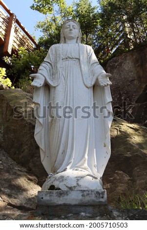 A white statue in the middle of a mountain under a blue sky
