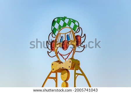 An image of a clown made of metal in a park on an amusement ride. Soft focus. Close-up