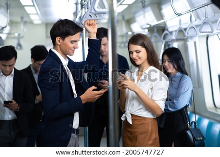 Man and woman couple passengers talking on Urban Public Transport Metro. Business people go to work by public transport Royalty-Free Stock Photo #2005747727