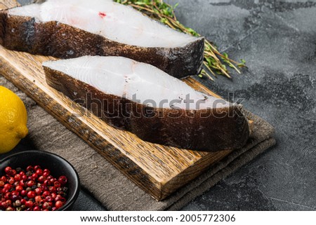 Fresh steak raw fish halibut set, with ingredients and rosemary herbs, on gray stone table background