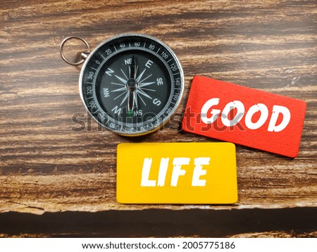 Business concept. Text GOOD LIFE on coloful board with compass on wooden table background.