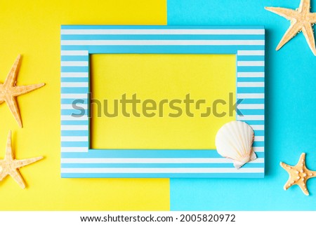 Picture frame with copy space and starfish on a yellow-blue background