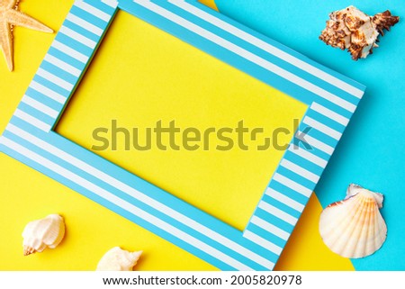 Picture frame with copy space and starfish on a yellow-blue background