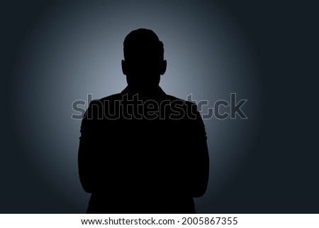 Silhouette of anonymous man on dark background Royalty-Free Stock Photo #2005867355