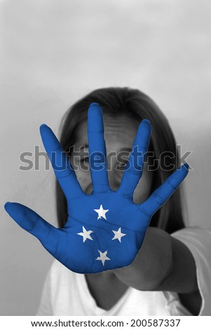woman with her hands signaling to stop and Micronesia flag