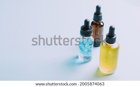 Cosmetic products gel serum lubricant hyaluronic acid with oxygen bubbles glass vials with a pipette blue background