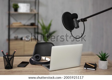 blogging and podcasting concept - home studio desk with microphone and laptop for recording and streaming
