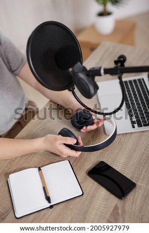 journalism, podcast and blogging concept - workplace of blogger or journalist with laptop, notepad, headphones and microphone