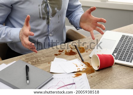 Man with spilled coffee over his workplace and shirt, closeup Royalty-Free Stock Photo #2005938518