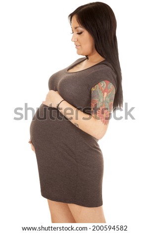 A side view of a pregnant woman holding on to her belly.