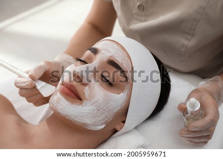 Young woman during face peeling procedure in salon Royalty-Free Stock Photo #2005959671