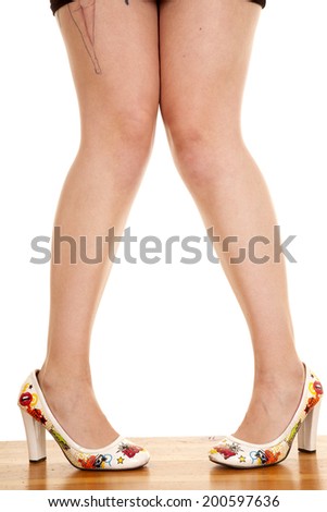 a woman with a tattoo on her leg, wearing fun shoes.
