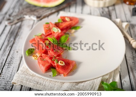 Bio watermelon with nuts, basil and olive oil