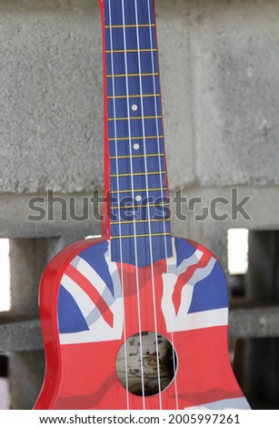 The Great Britain flag acoustic guitar hanging on the block wall.