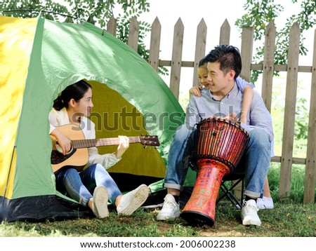 Happy family of three camping outdoors high quality photo