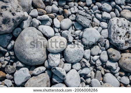 Smooth stones on a beach pictured from above
