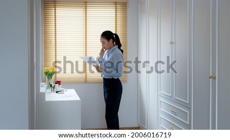 Young female leader, asia people lady or mba student standing look in front of mirror fear tired pep talk for sale pitch hold paper document script public speak skill for job career lost self improve. Royalty-Free Stock Photo #2006016719