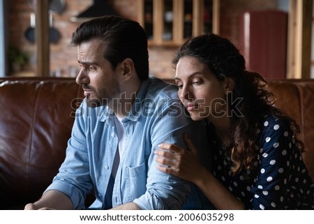 Wife expressing empathy and compassion to sad frustrated husband, going through grief, crisis, sorry for loss, hugging. Woman embracing man, holding shoulders, giving comfort and support Royalty-Free Stock Photo #2006035298