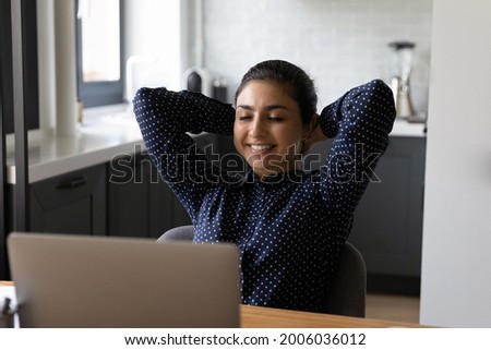 Happy relaxed employee working at computer from home, taking break. Student sitting at laptop, leaning on back with closed eyes, smiling, enjoying good job result, relaxation, comfortable workplace Royalty-Free Stock Photo #2006036012