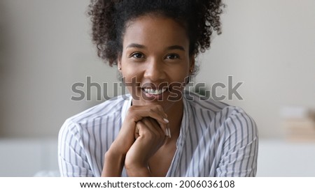 Head shot portrait close up happy beautiful African American woman with healthy toothy smile and perfect smooth skin, positive young female posing for photo, profile picture, blogger recording video