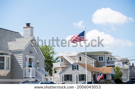 American flag waving in the wind in front of beach houses celebrating the 4th of July, Long Beach Island, NJ, LBI background