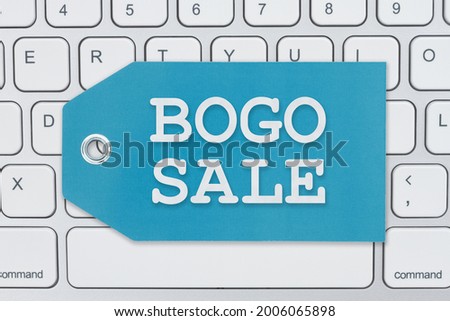 BOGO Sale message on a gift tag on gray keyboard for your online sales Royalty-Free Stock Photo #2006065898