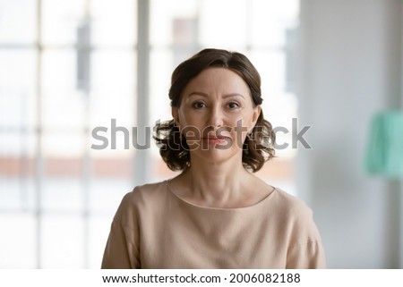 Profile picture of happy optimistic Caucasian mature 50s woman pose in own home. Headshot portrait of smiling beautiful middle-aged female renter or tenant indoors. Elderly, maturity concept.