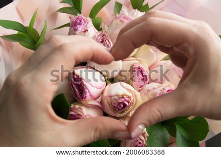 palms in the shape of a heart on a background of white-pink roses.Valentines day.