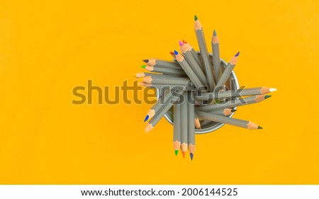 Organizer with color pencils. School stationery concept background with yellow desktop. Top view and copy space 