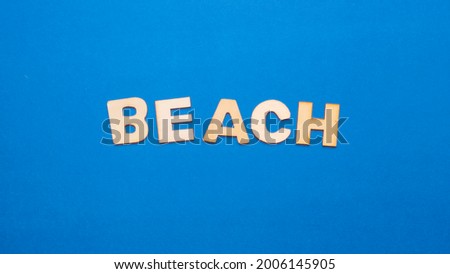 Wooden letters with the written English word "Beach" on blue background