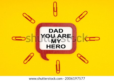 People and education concept. On a yellow background, paper clips and a mental plaque with the inscription - Dad You Are My Hero