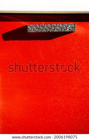 Red door with shiny handle. Door handle on the bright door, close up. Modern interior.Creative abstract image.