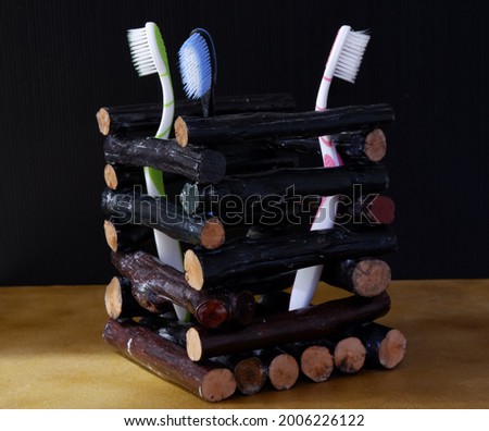 Crafts from longan wood that are formed into colored containers and three tooth brush inside. DIY craft from longan wood