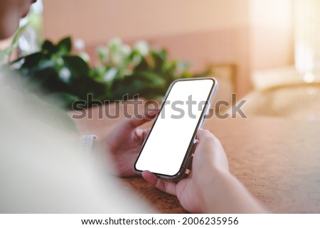 Close up of woman using mobile blank smart phone and credit card sending massages in the coffee shop