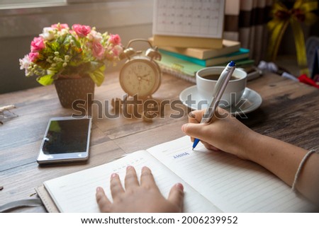 Planner plan Schedule Calendar and reminder agenda, work online at home. Women hand planning daily appointment and write holiday trip in diary at office desk. Calendar reminder event concept.