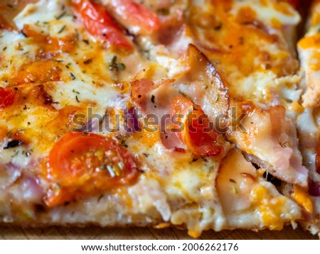 close-up of a piece of juicy pizza with bacon slices. Top view, flat lay. Italian dish