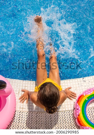 Child Splashes water in the pool. Selective focus. Kid.