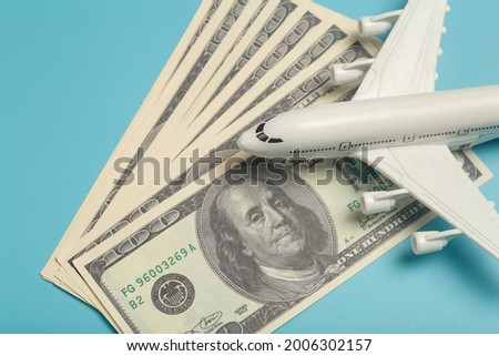 Airplane and money. Plane on the background of USA dollars. The cost of travel, air tickets and flights, financial expenses for vacation.