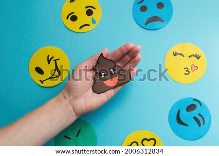 top view arrangement with different emotions.day of a smile, a face with emotions made of paper, shows the mood of a turd on your hand