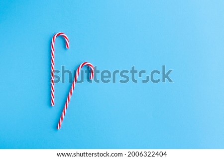 Christmas composition. Christmas two candy canes flat lay, top view on pastel pink background.Holiday festive celebration greeting card with copy space fo text. Christmas background with candy canes