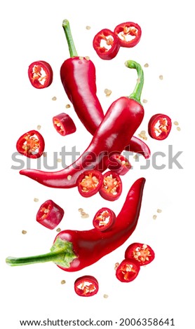 Fresh red chilli peppers and cross sections of chilli pepper with seeds floating in the air. File contains clipping paths. Royalty-Free Stock Photo #2006358641