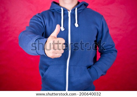 Guy in blouse with hood showing thumb up.