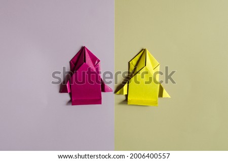 Conceptual paper cars of yellow and red colors on a two-color background close-up. Racing cars made of colored origami paper