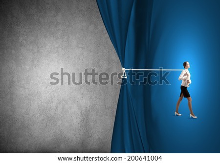 Young businesswoman pulling curtain with rope. Place for text