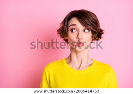 Photo portrait of curious girl looking empty space with pouted lips isolated on pastel pink color background