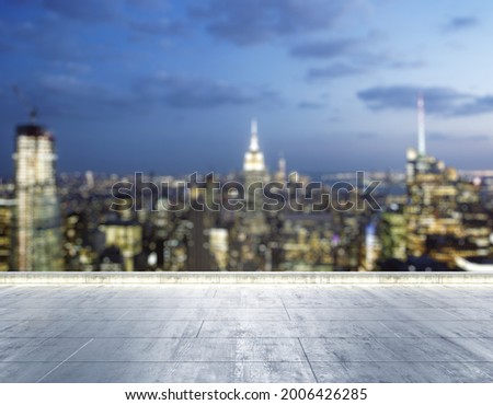Empty concrete dirty rooftop on the background of a beautiful blurry New York city skyline at night, mock up